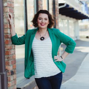 Katie Dooley,k brand strategist, a woman with brunette hair in a green blazer is smiling at the camera