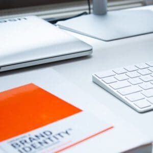 Minimalist desktop with bright orange brand book