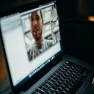 An angled shot of a blurry laptop with a video conference on screen